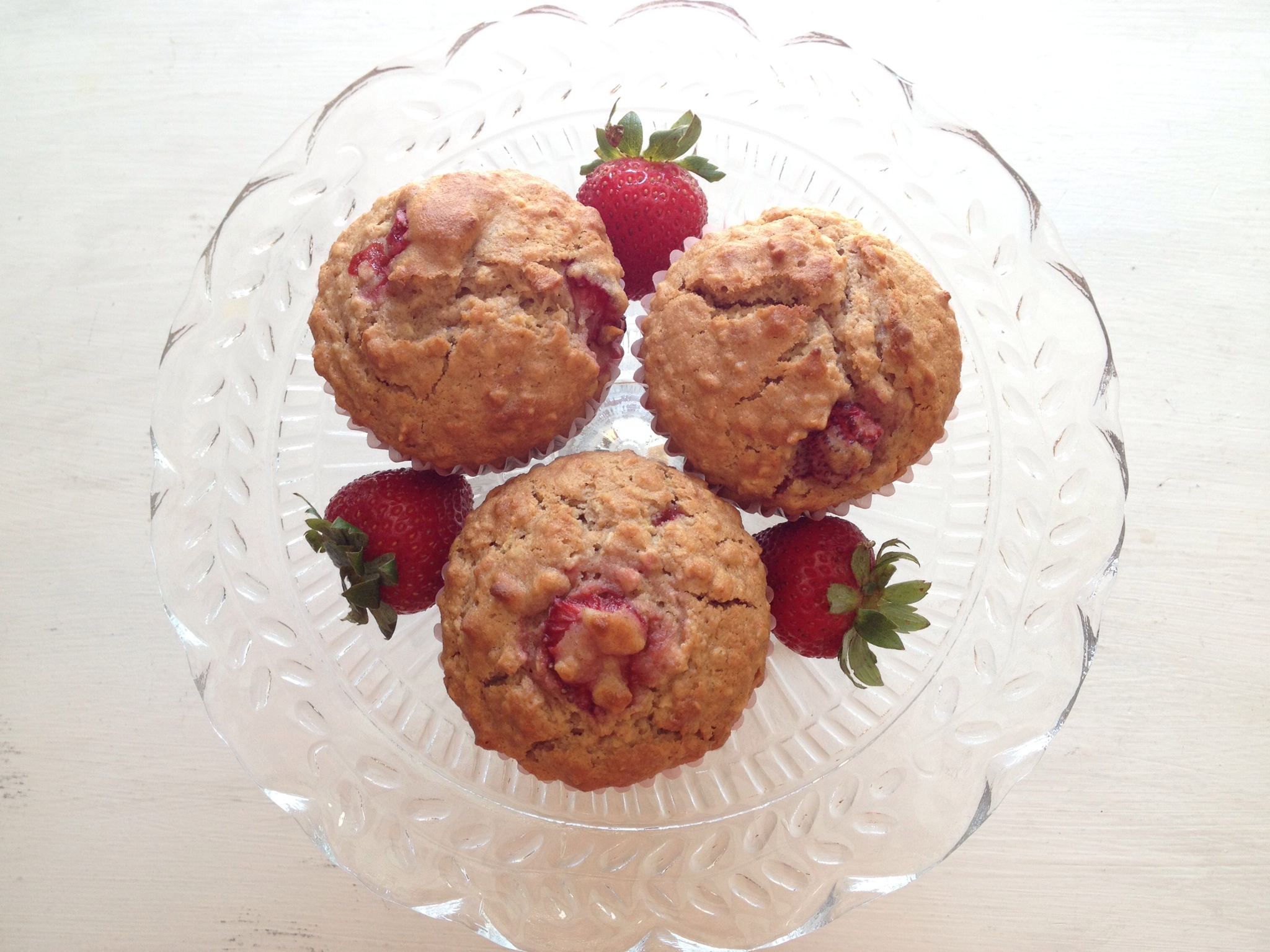 dish of strawberry oatmeal muffins and strawberries 